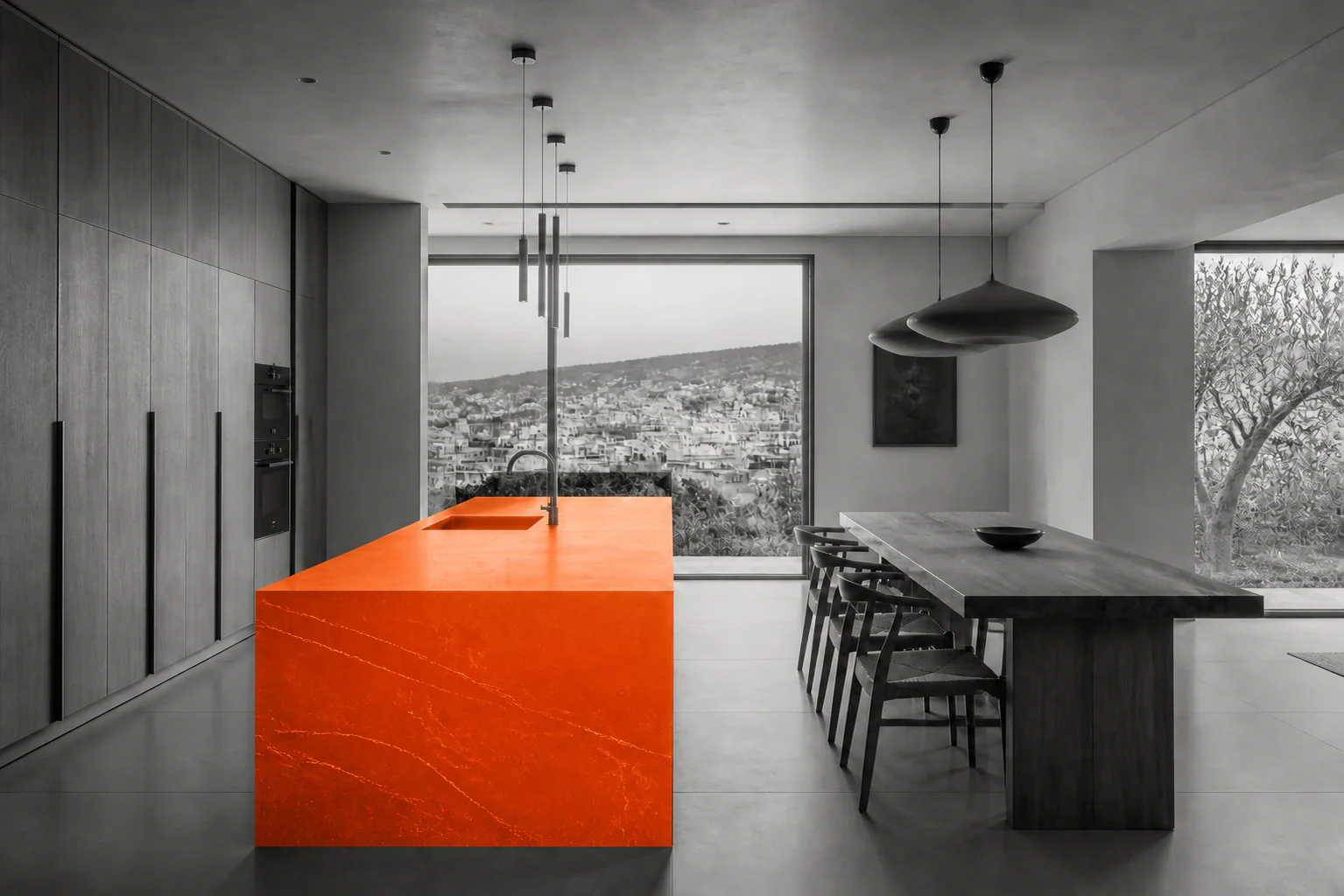Monochrome kitchen with a saturated orange island overlooking the hills of Nablus